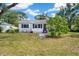 Charming home with lush front yard featuring small bench and colorful flower accents at 215 35Th Ne Ave, St Petersburg, FL 33704