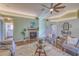 Cozy living room with fireplace, comfortable seating, and a ceiling fan, perfect for relaxing and entertaining at 3295 Hibiscus Dr, Hernando Beach, FL 34607