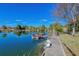 Picturesque waterfront view with a dock, complemented by lush greenery and blue skies at 3295 Hibiscus Dr, Hernando Beach, FL 34607