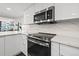 Modern kitchen featuring stainless steel appliances and white cabinetry at 6260 Kipps Colony Ct # 204, Gulfport, FL 33707