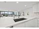 Modern kitchen with white cabinets, quartz countertops and a large sink at 6260 Kipps Colony Ct # 204, Gulfport, FL 33707
