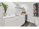 Modern wet bar with white cabinetry, wine storage, and quartz countertop at 6260 Kipps Colony Ct # 204, Gulfport, FL 33707