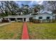 Traditional home with a brick walkway, green lawn, and neutral color scheme at 637 Jamaica Ave, Tampa, FL 33606