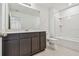 This bathroom features a double vanity, tile floors, and a shower with a tub at 10533 Hidden Banks Gln, Parrish, FL 34219