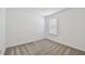 This simple bedroom features neutral carpeting and a window overlooking the backyard at 10533 Hidden Banks Gln, Parrish, FL 34219