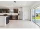 Modern kitchen featuring stainless steel appliances, dark cabinetry, a center island, and sliding glass doors to the exterior at 10533 Hidden Banks Gln, Parrish, FL 34219