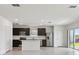 Modern kitchen featuring stainless steel appliances, dark cabinetry, a center island, and sliding glass doors to the exterior at 10533 Hidden Banks Gln, Parrish, FL 34219