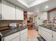 Kitchen with white cabinets, black appliances, and a view to living area at 10556 Blythville Rd, Spring Hill, FL 34608