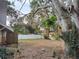 View of the spacious backyard with trees and a white fence at 1182 Norwood Ave, Clearwater, FL 33756