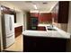 Well-lit kitchen featuring cherry wood cabinets, stainless steel appliances, and quartz countertops at 1182 Norwood Ave, Clearwater, FL 33756