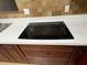 Modern black glass electric cooktop set in white quartz countertop at 1182 Norwood Ave, Clearwater, FL 33756