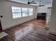 Living room with striped wood floors, large windows, and a piano at 1182 Norwood Ave, Clearwater, FL 33756