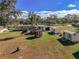 Sprawling yard with lush landscaping, multiple storage buildings and serene gazebo; idyllic backyard retreat at 11945 Carmen Ave, Dade City, FL 33525