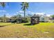 Spacious backyard featuring a gazebo, tropical palm and screened-in pool area at 11945 Carmen Ave, Dade City, FL 33525