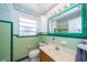 Bathroom with stylish flamingo wallpaper border and vintage green tiling at 11945 Carmen Ave, Dade City, FL 33525