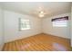Neutral bedroom with wood laminate floors, bright windows, and a ceiling fan at 11945 Carmen Ave, Dade City, FL 33525