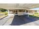 Carport and home front exterior with screened porch and well-maintained landscaping at 11945 Carmen Ave, Dade City, FL 33525