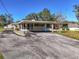 A lovely home front featuring a carport and well-maintained landscaping under a clear blue sky at 11945 Carmen Ave, Dade City, FL 33525