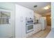 A closer view of the kitchen with white cabinets and modern built-in appliances at 11945 Carmen Ave, Dade City, FL 33525