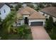 One-story house with brown roof, gray garage door and brick driveway, surrounded by neighborhood homes at 12241 Perennial Pl, Bradenton, FL 34211