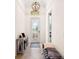 Bright entryway with tiled floor, bench, and a console table. Features a large chandelier at 12241 Perennial Pl, Bradenton, FL 34211