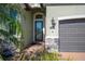 Front entry with glass door, stone accents, and a path leading to the garage at 12241 Perennial Pl, Bradenton, FL 34211