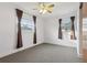 An empty bedroom with neutral carpet, a ceiling fan and two windows with brown curtains at 1593 76Th N Ave, St Petersburg, FL 33702
