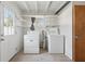 Bright laundry room with washer, dryer, and open shelving at 1593 76Th N Ave, St Petersburg, FL 33702