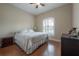 King-size bed in a bright bedroom with wood floors and window shutters at 1802 Pacific Dunes Dr, Sun City Center, FL 33573