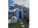Exterior shed with a black door and a small yard with tropical trees at 610 78Th Ave, St Pete Beach, FL 33706