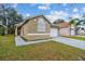 Tan one-story house with white garage door and partial view of neighboring houses at 816 Cape Cod Cir, Valrico, FL 33594