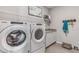 Functional laundry room with modern washer, dryer, overhead shelving, and countertop at 16026 10Th E Ave, Bradenton, FL 34212
