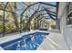 Inviting screened pool area with spacious patio and lush landscaping at 1903 Gulf Beach Blvd, Tarpon Springs, FL 34689
