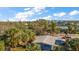 Aerial view of a light blue house with gray roof, nestled amongst palm trees at 3863 Belle Vista E Dr, St Pete Beach, FL 33706
