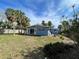 Spacious backyard with grassy lawn, mature palm trees and a partially visible shed at 3863 Belle Vista E Dr, St Pete Beach, FL 33706