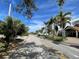 Residential street lined with palm trees and houses at 3863 Belle Vista E Dr, St Pete Beach, FL 33706