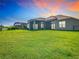 Spacious backyard with a screened patio, lush green lawn, and a glimpse of the pool area at 3901 Tour Trce, Land O Lakes, FL 34638