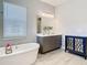 Bathroom features a soaking tub, dual sink vanity, and decorative cabinet for ample storage at 3901 Tour Trce, Land O Lakes, FL 34638