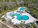 Aerial view showcasing a resort-style pool area with multiple pools, lounge chairs, and lush landscaping at 3901 Tour Trce, Land O Lakes, FL 34638
