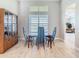 Bright dining room featuring a glass-top table, four chairs, and display cabinet at 3901 Tour Trce, Land O Lakes, FL 34638