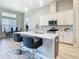 Bright kitchen with large island, quartz countertops, stylish pendant lighting, and adjacent dining area at 3901 Tour Trce, Land O Lakes, FL 34638