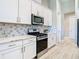 Close up of a modern kitchen featuring stainless steel appliances and white cabinetry at 3901 Tour Trce, Land O Lakes, FL 34638