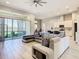 Open-concept living room with a large sectional, tile floors, and views of the lake and kitchen at 3901 Tour Trce, Land O Lakes, FL 34638