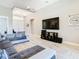 Stylish living room featuring tray ceiling, large TV, sectional sofa, and views to entryway at 3901 Tour Trce, Land O Lakes, FL 34638