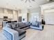 Spacious living room showcasing an oversized sectional, light tile flooring, and open access to the kitchen at 3901 Tour Trce, Land O Lakes, FL 34638