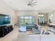 Bright living room featuring a large sectional sofa, modern fan, and sliding glass doors to the outdoors at 3901 Tour Trce, Land O Lakes, FL 34638