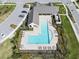 Aerial view of a community pool and clubhouse with manicured landscaping and ample lounge seating at 3901 Tour Trce, Land O Lakes, FL 34638