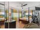 Bedroom with four-poster bed, ceiling fan, and large windows dressed with yellow and blue curtains at 4659 Helena Ne St, St Petersburg, FL 33703