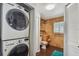 Laundry room with a stacked washer and dryer, and a bathroom with tiled walls and floors at 4659 Helena Ne St, St Petersburg, FL 33703