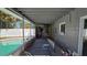 Covered outdoor patio adjacent to an outdoor pool containing storage and equipment at 4659 Helena Ne St, St Petersburg, FL 33703